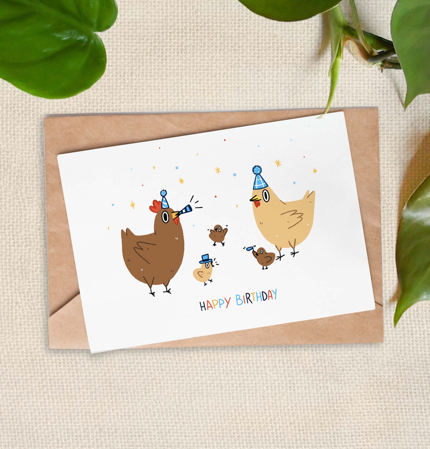 Greeting card illustration of two chickens wearing blue party hats, and 3 chicks. "Happy Birthday" is written in colorful text.