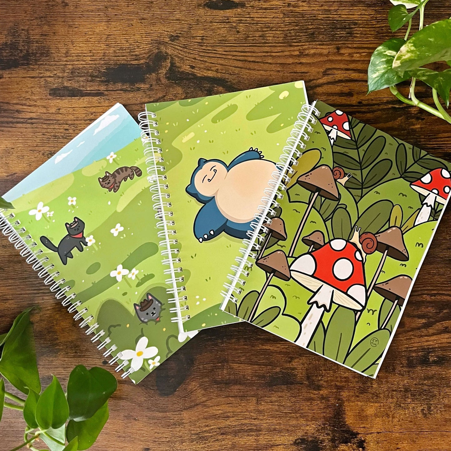 3 A5 Reusable Sticker books, one with cats, one with mushrooms and snails, and one with Snorlax.