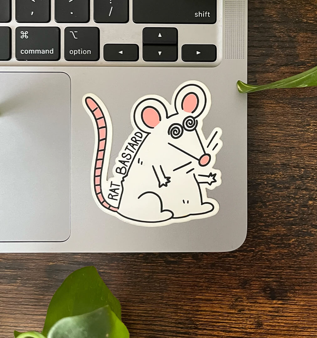 Rat bastard sticker of a cartoon white rat with pink ears, tail, and nose, and spirals for eyes with the text "Rat Bastard" sitting on a laptop.
