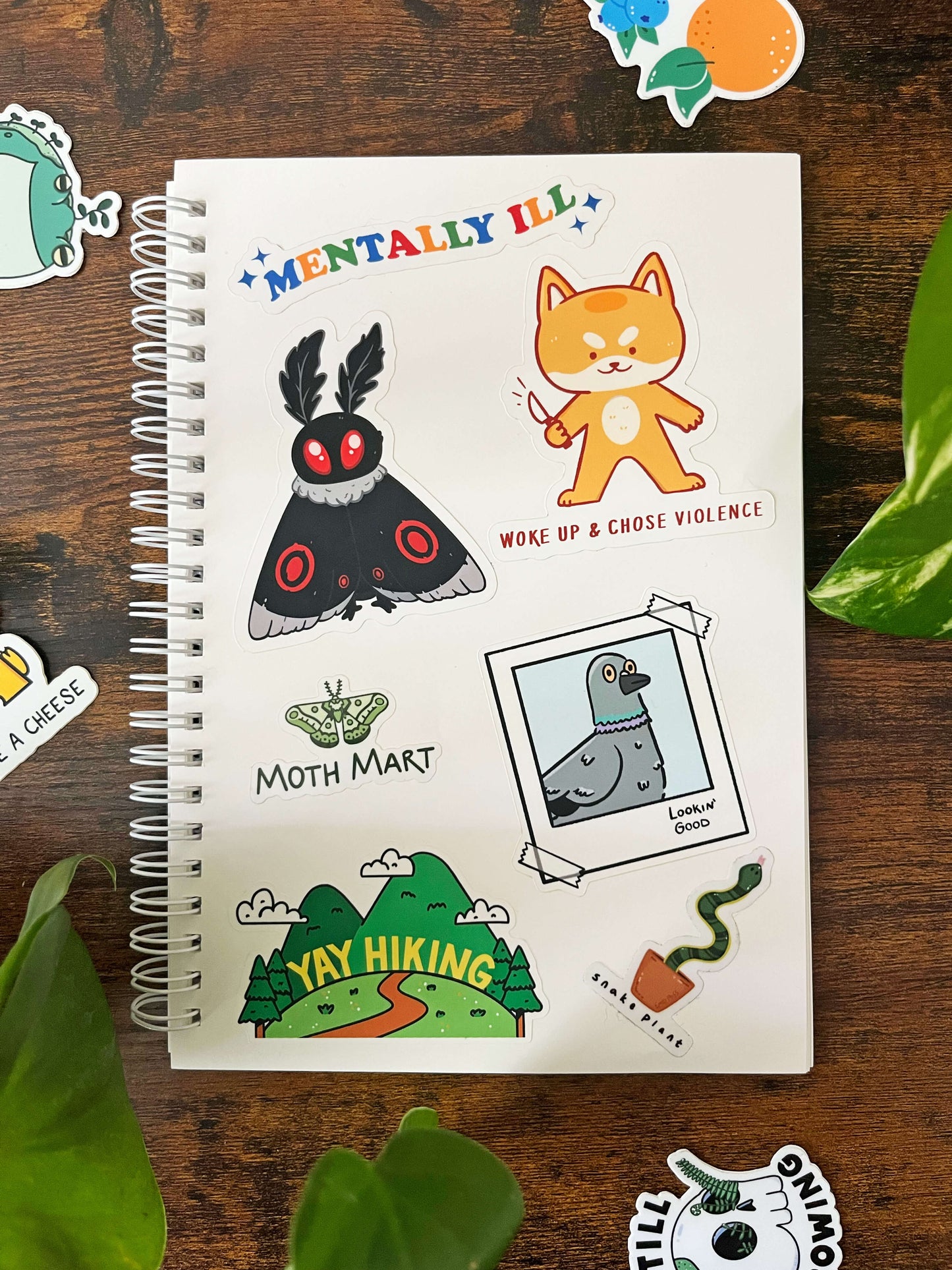 A5 Reusable Sticker book page open with 7 stickers on the page and 4 off the page.