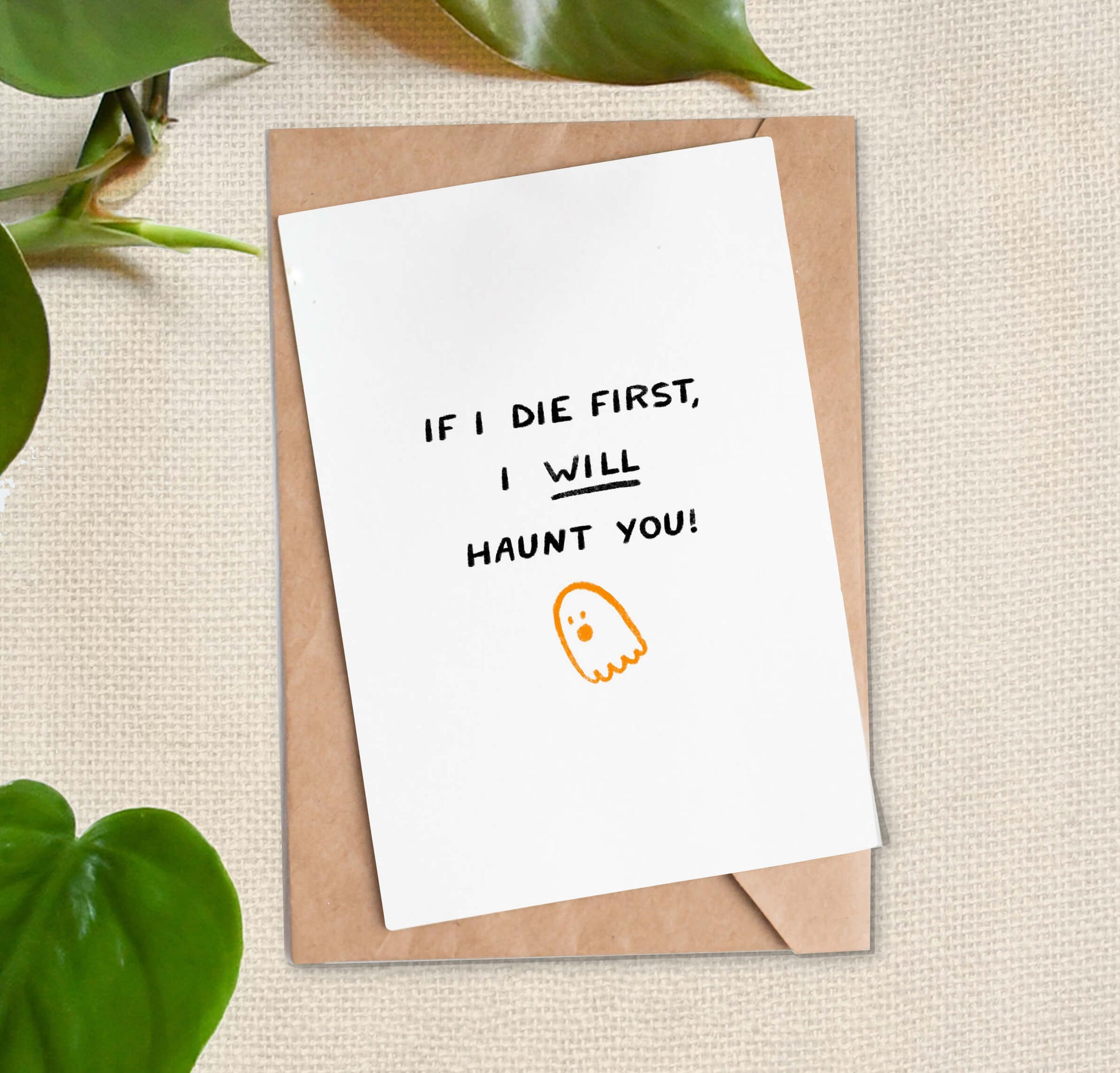 Greeting card with text reading "If I die first, I will haunt you!" and ghost illustration on a beige background