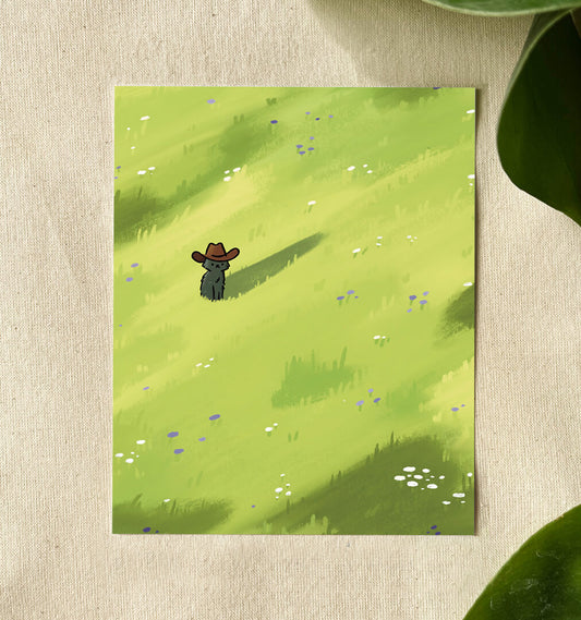 Illustration of a cute black cat wearing a cowboy hat stands in a bright green field dotted with purple and white wildflowers. This sits on a canvas background with green leaves. 