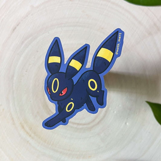 Dark-type cartoon character pocket monster sticker on a textured surface with leaves in the background
