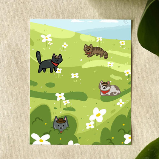 Illustration of 4 cats, one black, one brown tabby, one grey tabby, and one grey spotted, all wearing a red bandana and brown hat, sitting in a green field with white flowers.