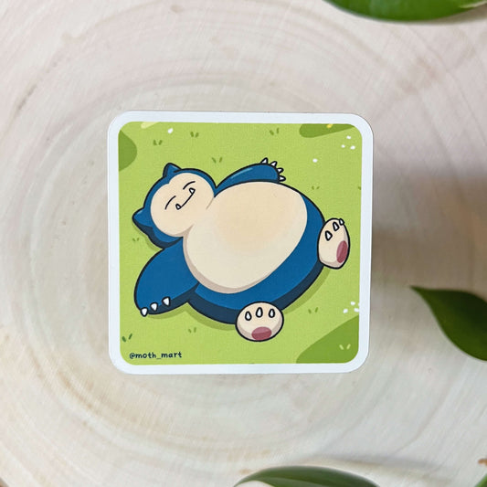 Illustration on a large blue creature laying on the grass on a wood background.
