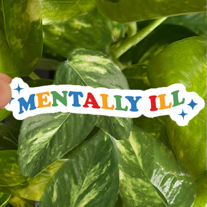 Sticker with blue, green, yellow, and red text reading "mentally ill" with star accents. 