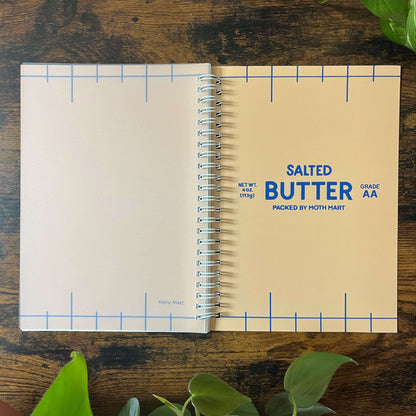 Reusable sticker book with 'Salted Butter' as the cover on a wooden surface with plants.
