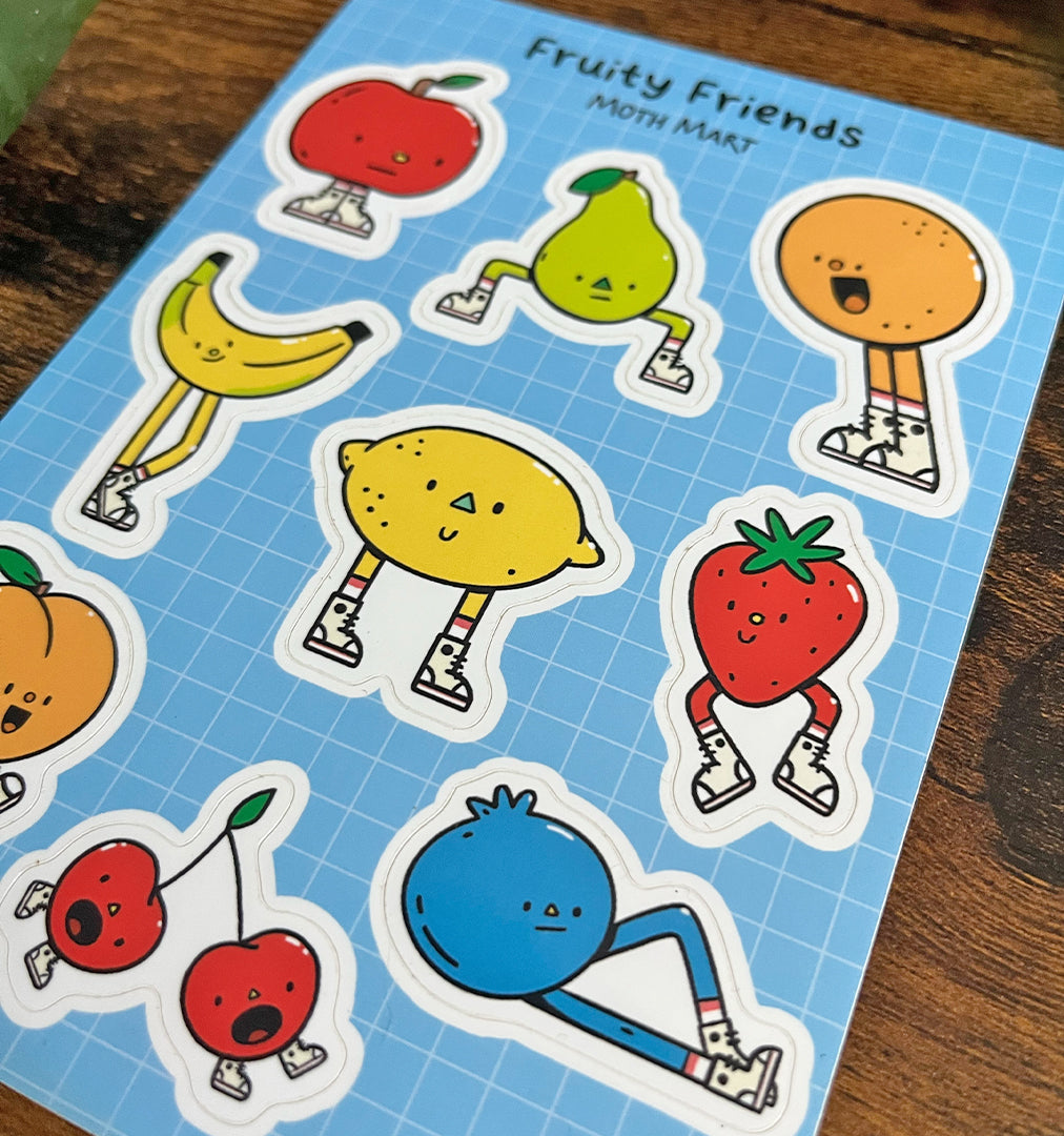 Closeup of cute fruity character sticker sheet on a blue background. Includes apple, pear, orange, banana, lemon, strawberry, peach, cherries, and blueberry, all in sneakers.