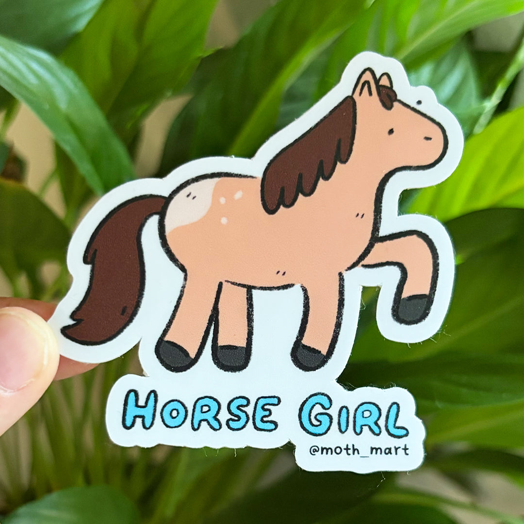 Sticker of a brown cartoon horse that says "Horse Girl" on a leafy background.