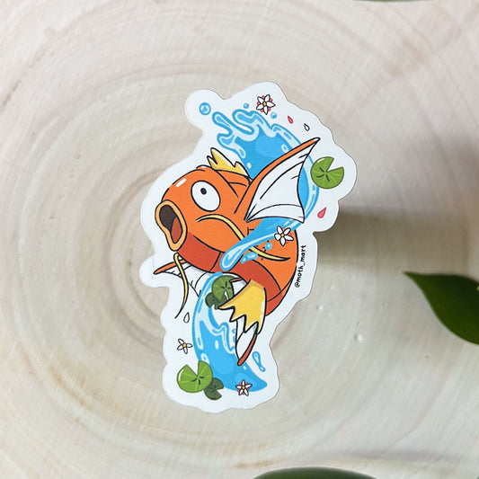 Colorful cartoon koi fish sticker on a wooden surface with leaves in the background.