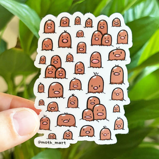 Mole cartoon characters on a dye cut sticker, held against a background of houseplants.