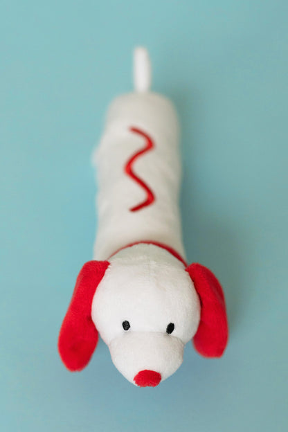 Plush dog toy with red accents on a light blue background