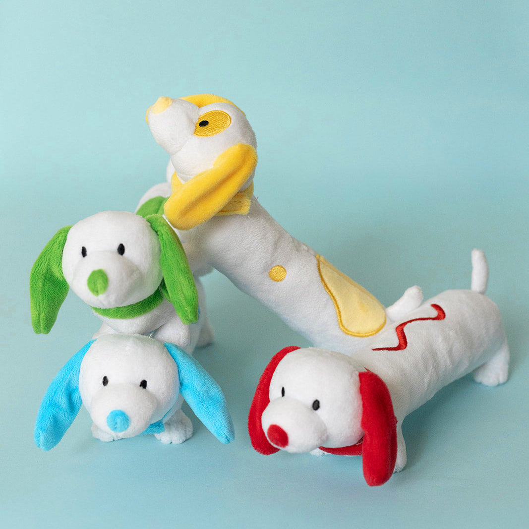 Set of four colorful dog-shaped toys on a light blue background