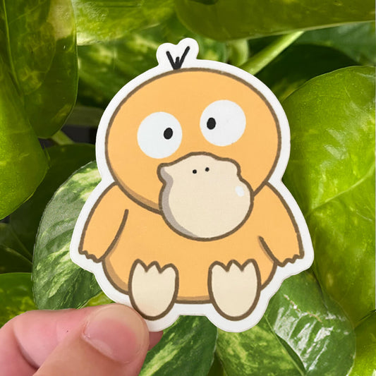 Sticker of yellow Pokemon duck, Psyduck, sitting and crosseyed. 