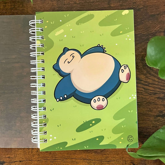 Re-usable sticker book with image of a large blue creature laying on grassy field. 