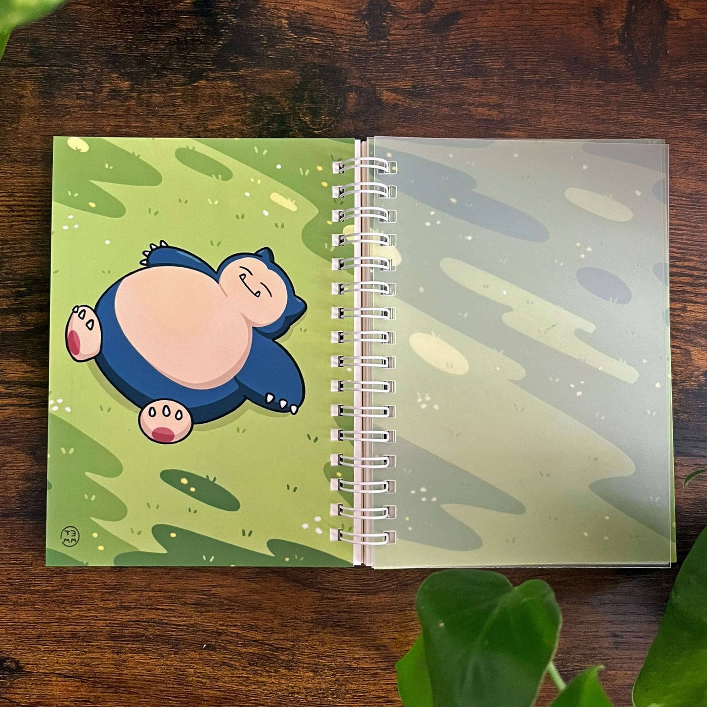 Open reusable sticker book, laying flat with image depicting a large blue creature with grass. 