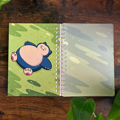 Open reusable sticker book, laying flat with image depicting a large blue creature with grass. 